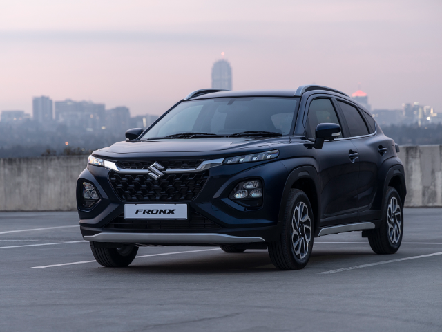 Three quarter view of a dark blue Suzuki Fronz with a city scape background