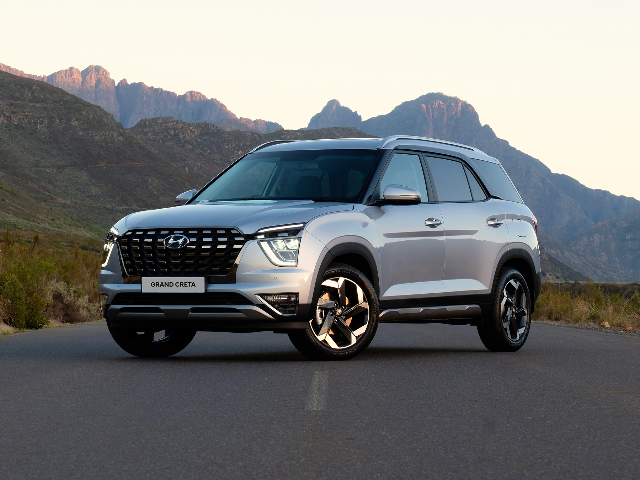 A silver Hyundai Grand Creta against a mountainous backdrop