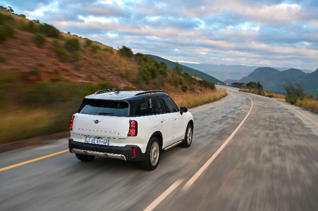 A white Countryman driving towards the mountains.