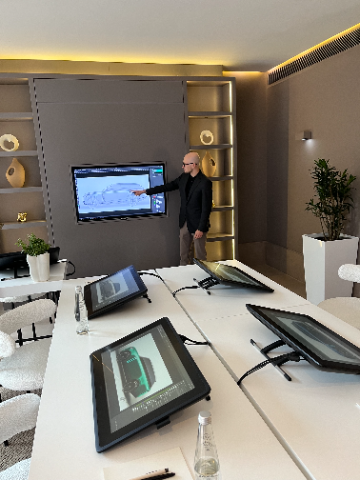 One of Land Rover's head designers standing in front of a digital Range Rover sketch.
