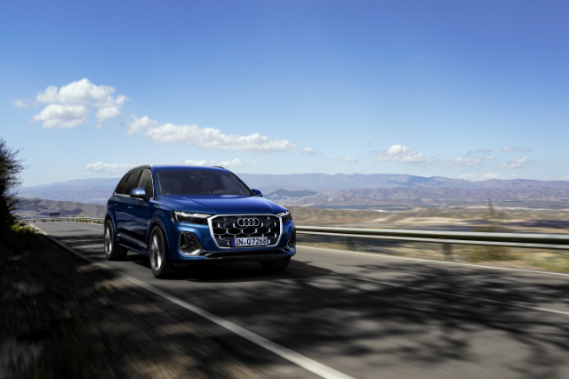 A blue Q7 driving a mountain pass.