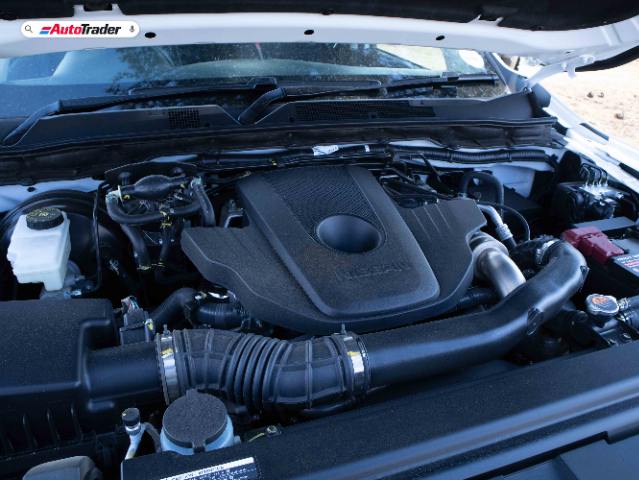 The image shows the engine bay of a Nissan Navara PRO-4X. The hood is open, revealing the engine and various components, including the air intake, battery, and fluid reservoirs. The Nissan logo is visible on the engine cover. The image is branded with the AutoTrader logo at the top.