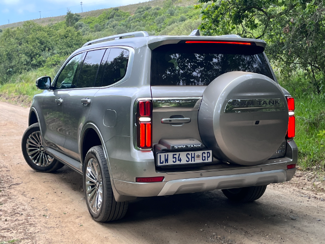 Three-quarter view of a golden Tank 500 on a dirt road.