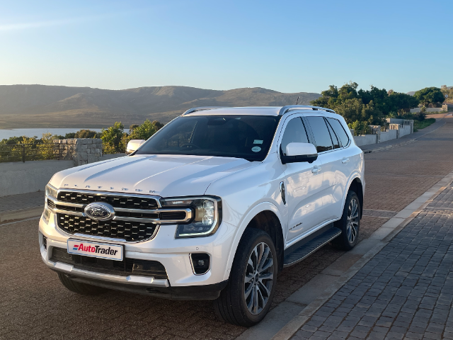 A white Ford Everest Platinum with hills and a lake in the background.