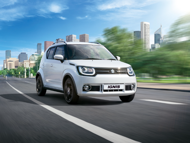 White Suzuki Ignis driving on a road