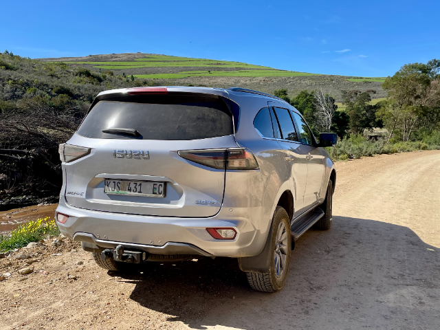 Rear view of the mu-X on a gravel road, ready for adventure.