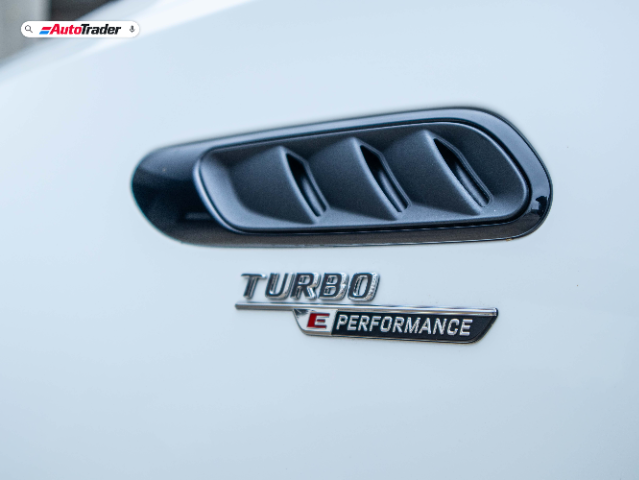 Close-up image of the side vent on a Mercedes-AMG C63S E-Performance, featuring a black vent cover. Below it, a badge reads "Turbo E Performance" in silver and red text. The "AutoTrader" logo is visible in the top left corner.