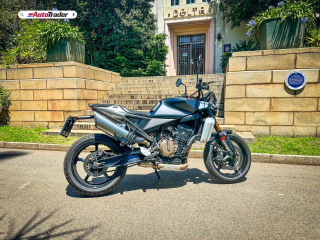 Husqvarna Svartpilen 801 parked in front of historical building