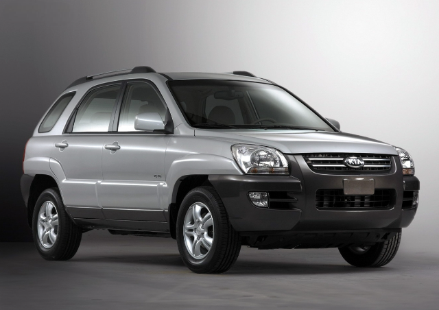 A silver grey Kia Sportage, first generation.