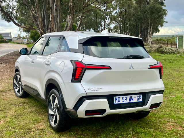 A pearl White Mitsubishi outlander, rear 3-quarter view.