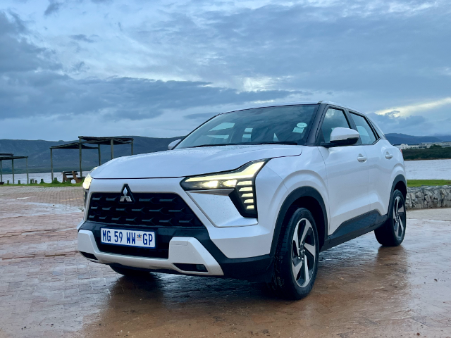 A white Mitsubishi Outlander parked in front of the lagoon.