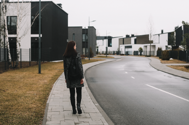 Woman waiting on the sidewalk.