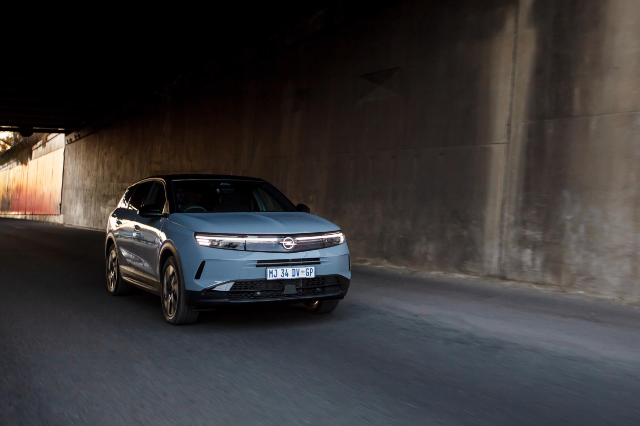 Opel's suave new Grandland driving under a bridge.