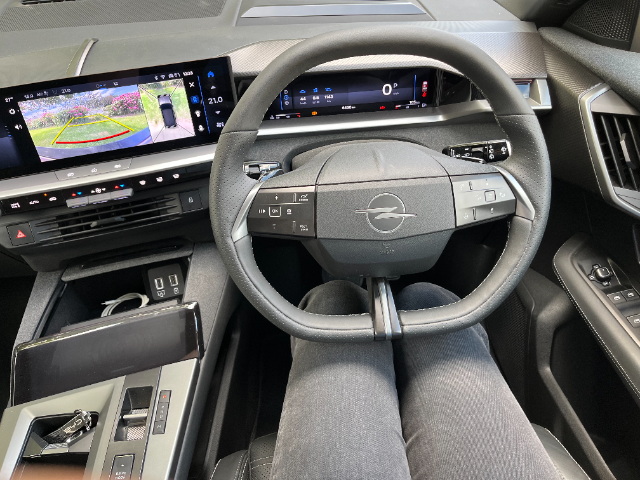 Just behind the steering wheel.