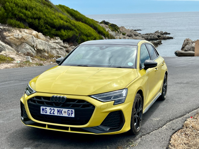 A yellow Audi A3 Sportback with the ocean in the background.