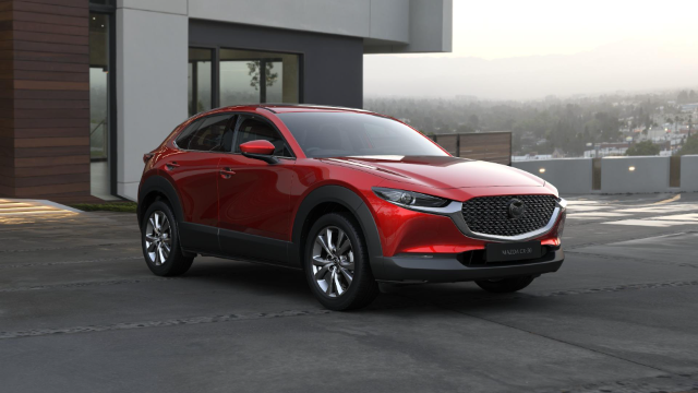 A red Mazda CX-30 in front of a minimalist house.