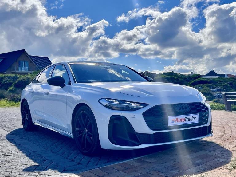 A white Audi A5 under a cloudy sky.