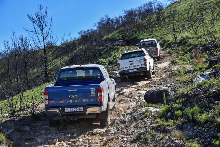 Ranger bakkies making their way up a hill.